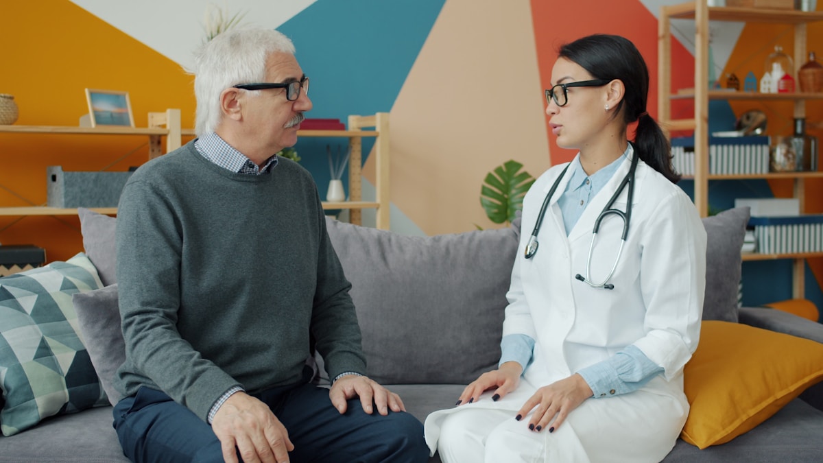 A support professional talking with an older adult recovering at home
