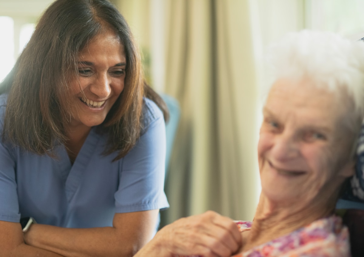 A care professional supporting an older adult, giving a family caregiver a break